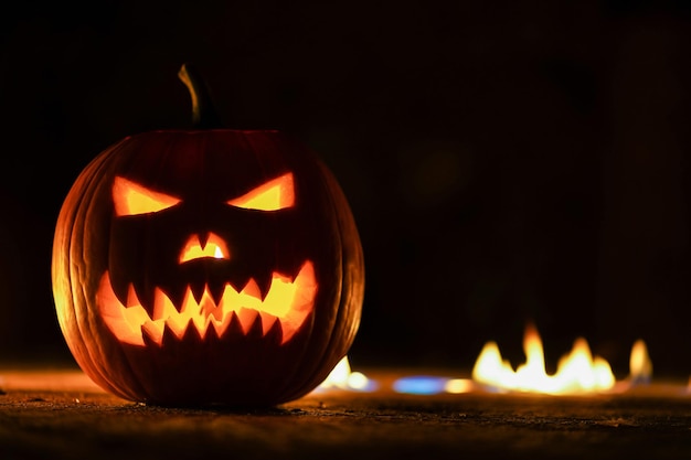 Beleuchtete Jack-o-Lampe mit Feuer im Hintergrund in der Nacht