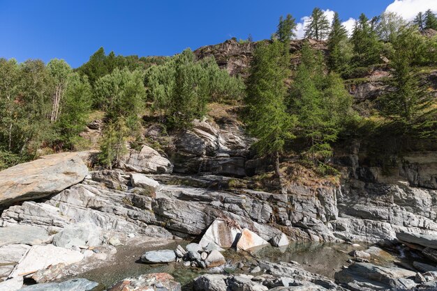 Beleuchtete Karstgranitfelsen Lillaz-Wasserfall und grüne Bäume um kleines Wasserbecken