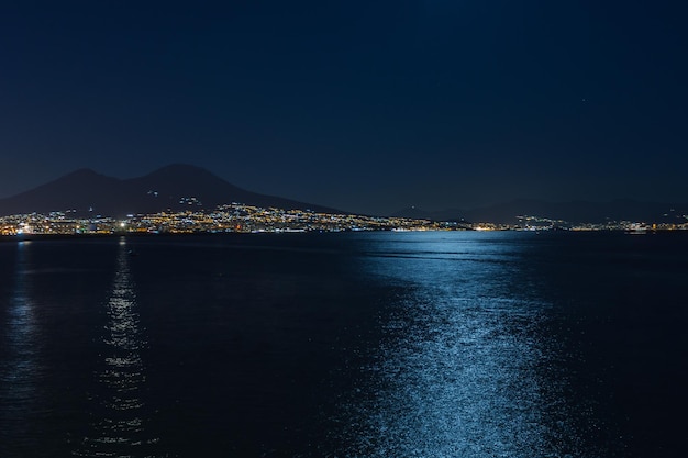 Beleuchtete Stadt am Meer gegen den klaren Himmel in der Nacht
