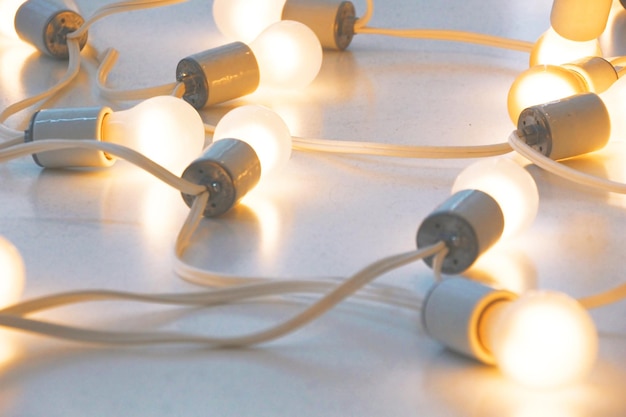 Foto beleuchtete weiße glühbirnen, die durch ein durchgehendes kabel verbunden sind