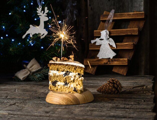 Foto beleuchteter funkel auf dem kuchen gegen den weihnachtsbaum