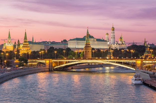 Beleuchteter Moskauer Kreml und Moskwa mit Brücke am Sommerabend. Rosa Himmel. Russland