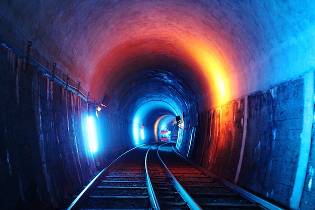 Foto beleuchteter tunnel mit eisenbahnschienen