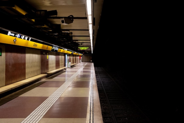 Beleuchteter U-Bahnsteig mit dunklen Gleisen