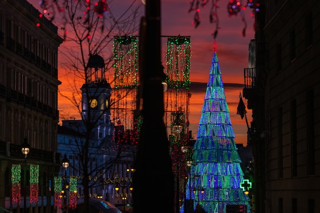 Beleuchteter Weihnachtsbaum, der in der Dämmerung in der Mitte des Platzes Puerta del Sol in Madrid steigt.