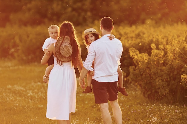 Beleuchtetes Bu-Sonnenlicht Eine vierköpfige Familie, die tagsüber im Sommer Freizeit auf dem Feld verbringt