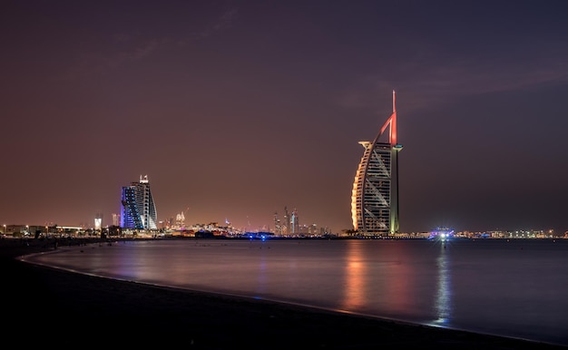 Foto beleuchtetes burj al arab hotel am meer gegen den himmel in der nacht