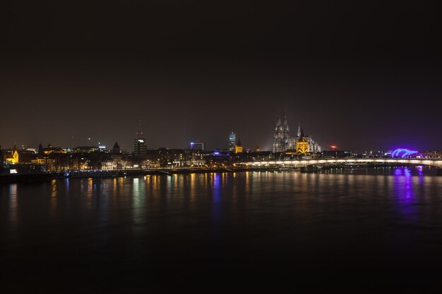 Beleuchtetes Stadtbild am Fluss in der Nacht