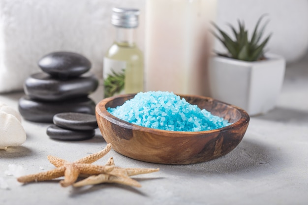 Beleza ainda vida de garrafa de óleo de massagem de sal de aroma essencial e natural de fragrância com pedras, velas na mesa de concreta cinza. Composição do tratamento de spa