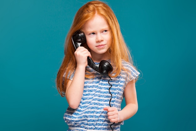 Beleza bonito menina na camiseta com cabelos longos falar um telefone