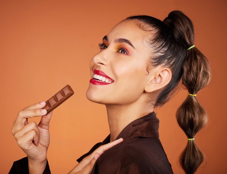 Foto beleza comendo e mulher de perfil com barra de chocolate junk food ou sobremesa para doces doces lanche ou refeição enganosa maquiagem facial cosméticos para cuidados com a pele e modelo de cabelo faminto com produto de cacau marrom