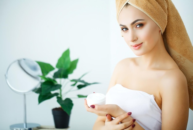 Beleza Cuidados com a pele Mulher bonita aplicando creme facial cosmético