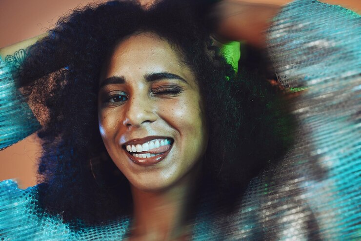 Foto beleza de cabelo e retrato de mulher negra piscando com afro em estúdio para produtos de beleza para cuidados com os cabelos e bem-estar salão de cabeleireiro de arte criativa e mulher feliz com movimento para cosméticos, moda e maquiagem