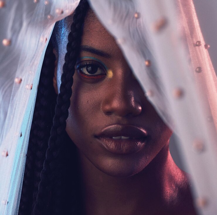 Foto beleza de retrato e maquiagem com uma mulher negra modelo em estúdio em um fundo cinza coberto com tecido cosméticos faciais e têxteis com uma mulher jovem e atraente posando para promover a pele natural