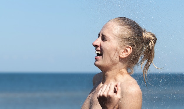 Beleza e estilo de vida saudável. Mulher nua ao ar livre. Mulher jovem e bonita nua tomando banho perto da piscina na praia