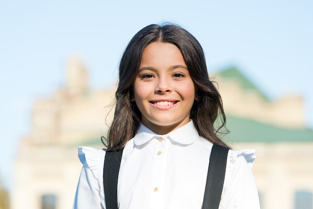 Beleza e moda infantil vintage. colegial em uniforme retrô elegante. pequena menina feliz pronta para estudar. moda antiga. de volta à escola. felicidade infantil. mercado de uniformes elegantes. aparência inteligente. sempre sorrindo.