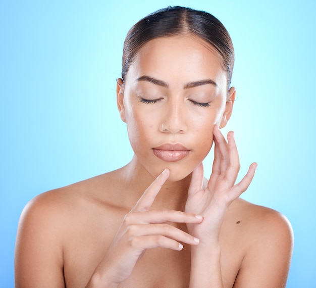 Beleza facial e cuidados com a pele com uma mulher negra modelo em estúdio em um fundo azul para tratamento natural Olhos faciais fechados e cosméticos com uma mulher jovem e atraente posando para promover cuidados com a pele