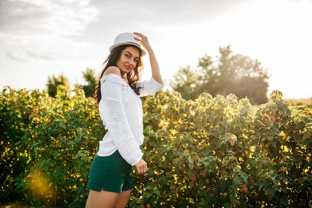 Beleza garota romântica ao ar livre linda modelo adolescente em vestido curto casual no campo na luz do sol soprando cabelo comprido outono tonificado em cores quentes