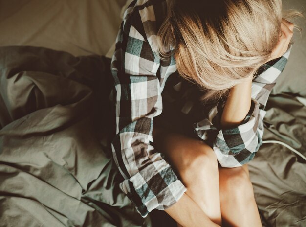 Beleza jovem feminina em uma camisa casual na cama