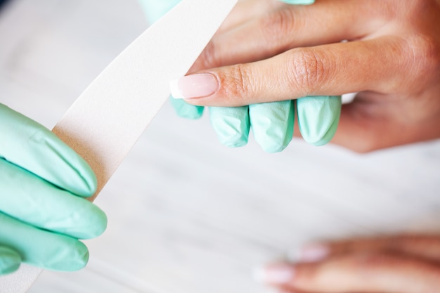 Beleza. Jovem mulher fazendo manicure em salão de beleza