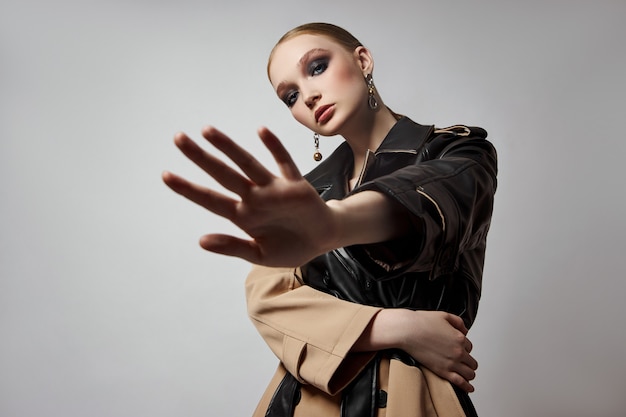 Foto beleza moda jovem em gabardine, maquiadora de rosto profissional. retrato de mulher em branco