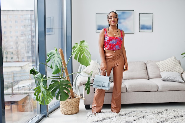 Beleza modelo afro-americano da moda mulher brasileira pose interior com bolsa.