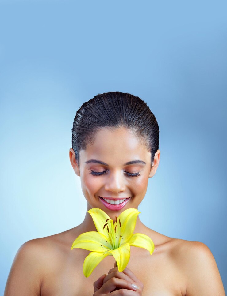 Foto beleza natural mulher e lírio em modelo de estúdio com sorriso cuidados orgânicos com a pele e cosméticos veganos cheiro de flor e pessoa feminina em fundo azul para bem-estar, paz e tratamento de spa saudável