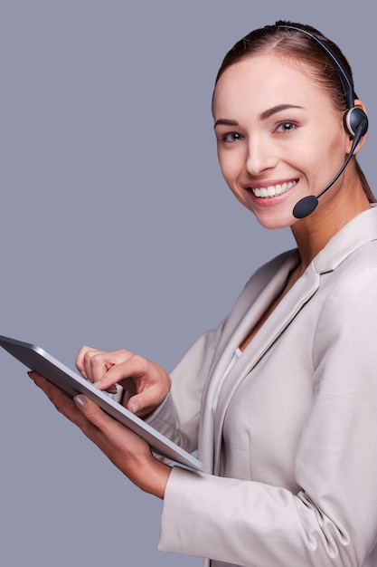 Beleza no trabalho. vista lateral da jovem operadora confiante segurando um tablet digital