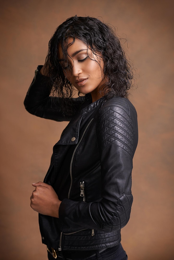 Foto beleza pensativa e mulher com casaco de couro de moda e garota confiante em um fundo de estúdio castanho modelo de roupas elegantes e pessoa indiana com roupas casuais e feliz com o extremo e à moda