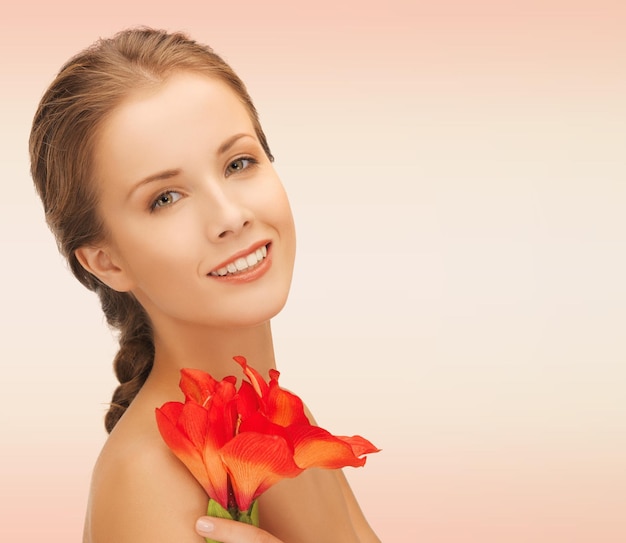 beleza, pessoas e conceito de saúde - bela jovem sorridente com flores e ombros nus sobre fundo rosa