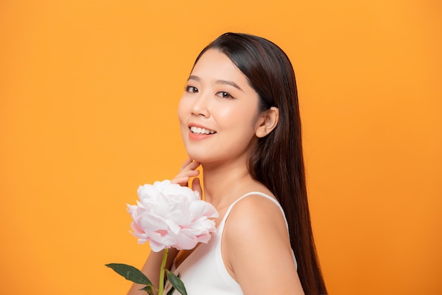 Beleza Pura. Menina segurando uma flor de peônia rosa