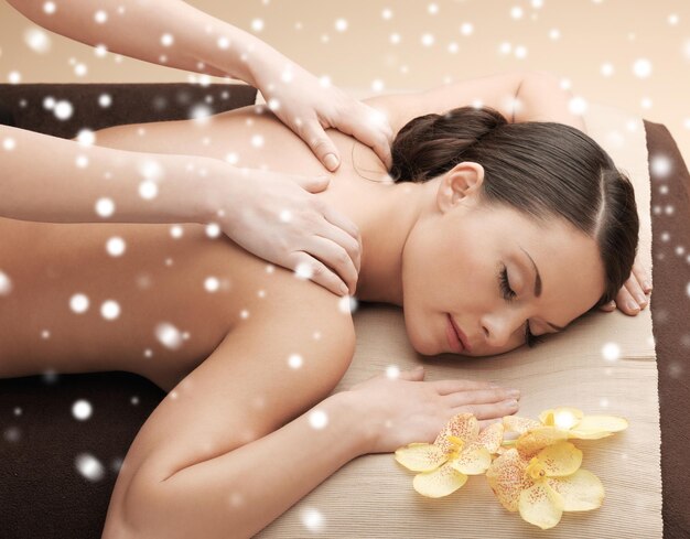 beleza, saúde, férias, pessoas e conceito de spa - bela jovem no salão de spa recebendo massagem