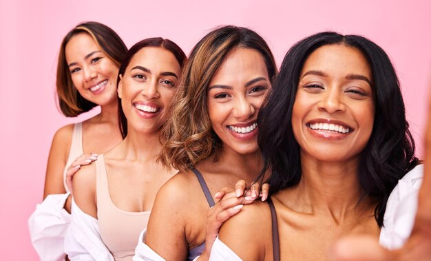 Foto beleza selfie e lingerie com amigas modelos em um fundo rosa em estúdio para cuidados naturais com a pele diversidade saúde e sorriso com o retrato de um grupo de mulheres posando para bem-estar ou inclusão