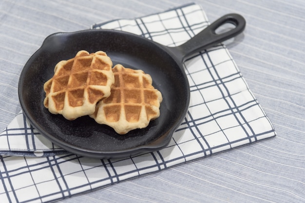 Bélgica waffle na panela na toalha da mesa