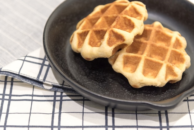 Bélgica waffle na panela na toalha da mesa