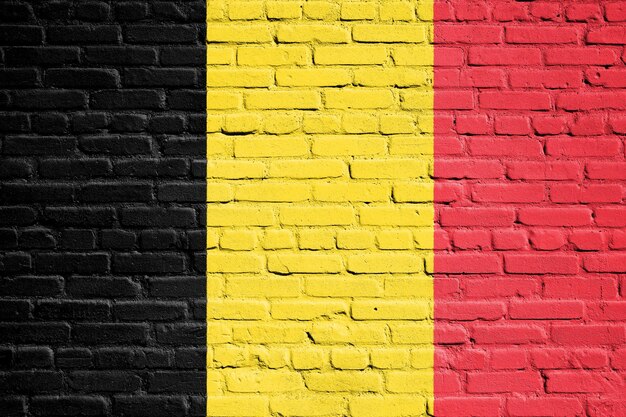Belgische Flagge auf der Ziegelsteinmauer gemalt