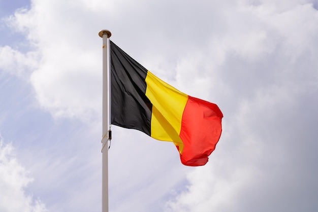 Belgische Flagge Belgiens winkt über einem bewölkten Himmel