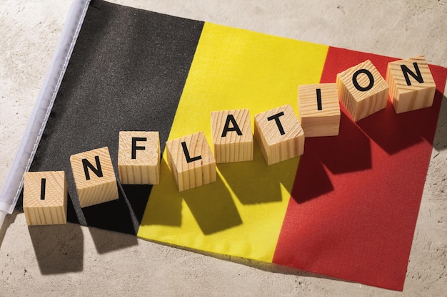 Belgische Flagge und Holzwürfel mit Text, Konzept zum Thema Inflation in Belgien