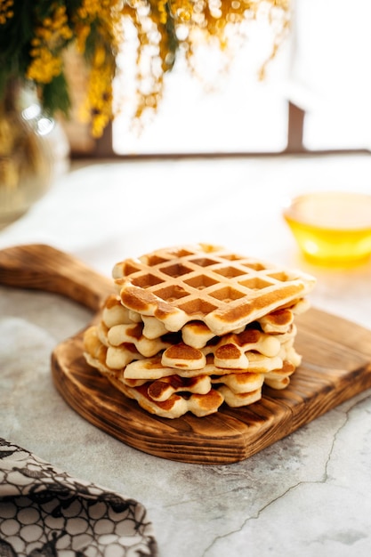 Belgische Waffeln auf einem Holzbrett auf dem Tisch Frühlingsatmosphäre