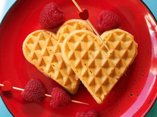 Belgische Waffeln in Form eines Herzens mit Himbeeren