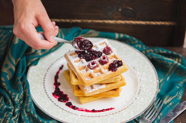 Belgische Waffeln mit Beeren werden mit Marmelade gegossen