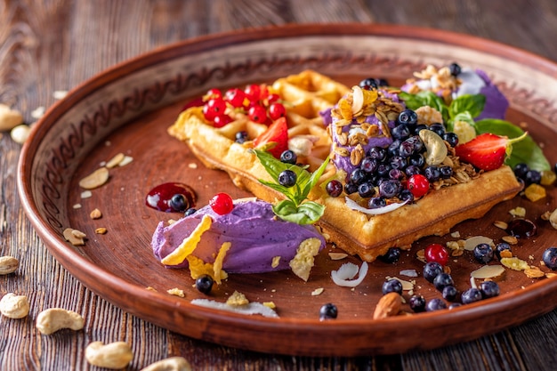 Belgische Waffeln mit Blaubeercreme, Müsli und frischen Beeren, leckeres Frühstück, horizontale Ausrichtung, Nahaufnahme