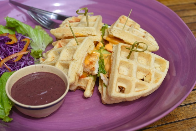 Belgische Waffeln mit gebratenem Hähnchen auf lila Teller in der Nähe