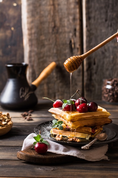 belgische Waffeln mit Honig. Kirschen Kaffeebohnen im Glas.