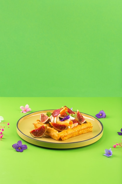 Belgische Waffeln mit Sahnefeigenblumen und Beeren hochwertiges Foto