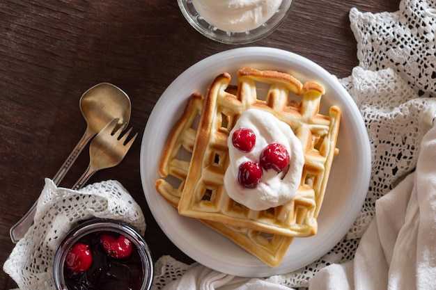 Foto belgische waffeln mit sauerrahm und kirschmarmelade