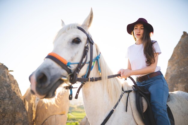 Bella chica al aire libre en las montañas con su fiel caballo