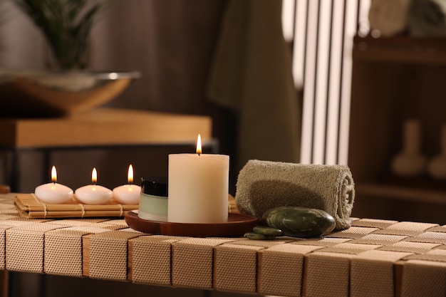 Bella composición con diferentes productos de spa en un banco de mimbre en el interior