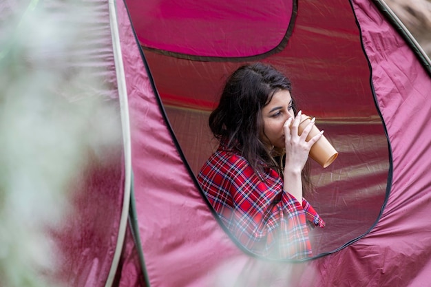 Bella dama bebiendo café en el camping