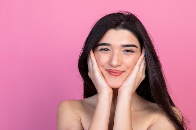 La bella dama llevándose las manos a la cara y sonriendo a la cámara Foto de alta calidad